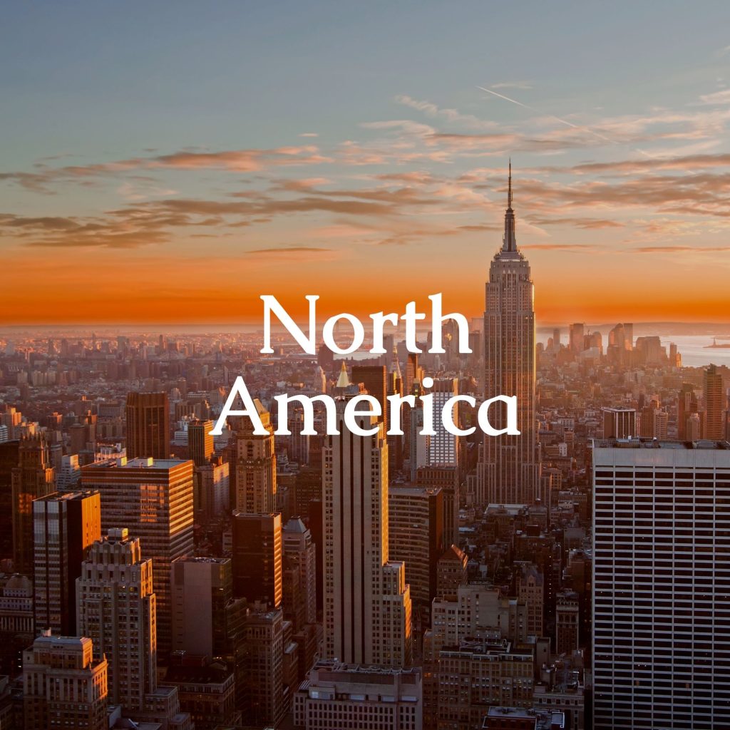 Sunset with a view of skyscrapers in New York, with the text 'North America' in the foreground.